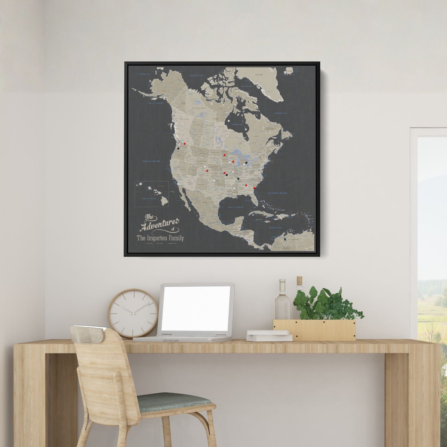 Personalized earth toned North America travel map with push pins in black frame above wooden desk