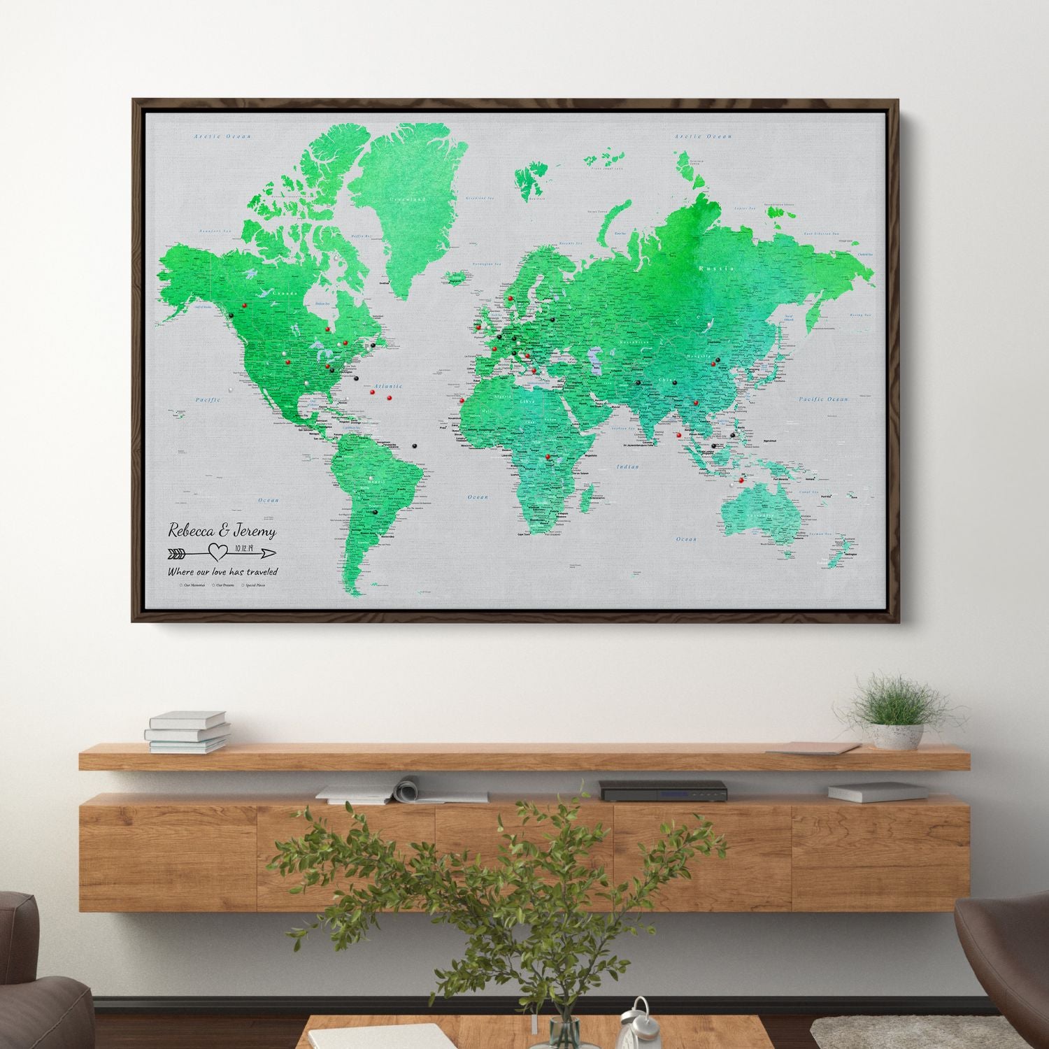 Enchanting Emerald watercolor world travel map canvas with pins hanging in modern living room