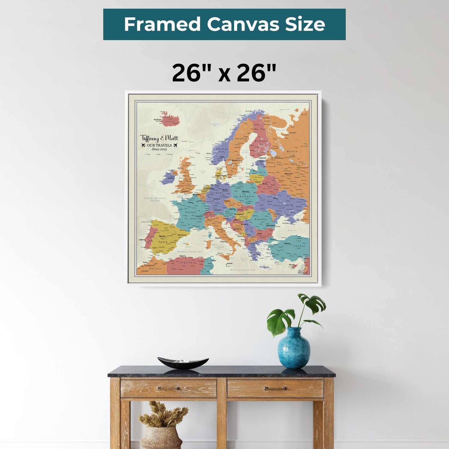 26x26 framed canvas Europe travel map with colorful countries hung above wooden console table