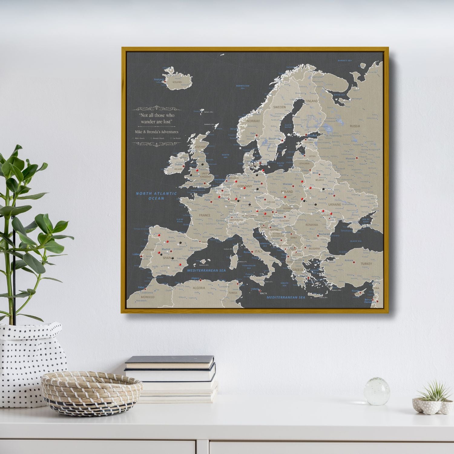 Earth toned Europe travel map canvas with red pins in gold float frame on white wall