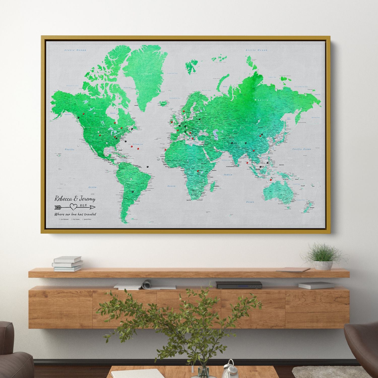 Enchanting Emerald watercolor world travel map canvas in gold frame hanging above wooden floating shelf