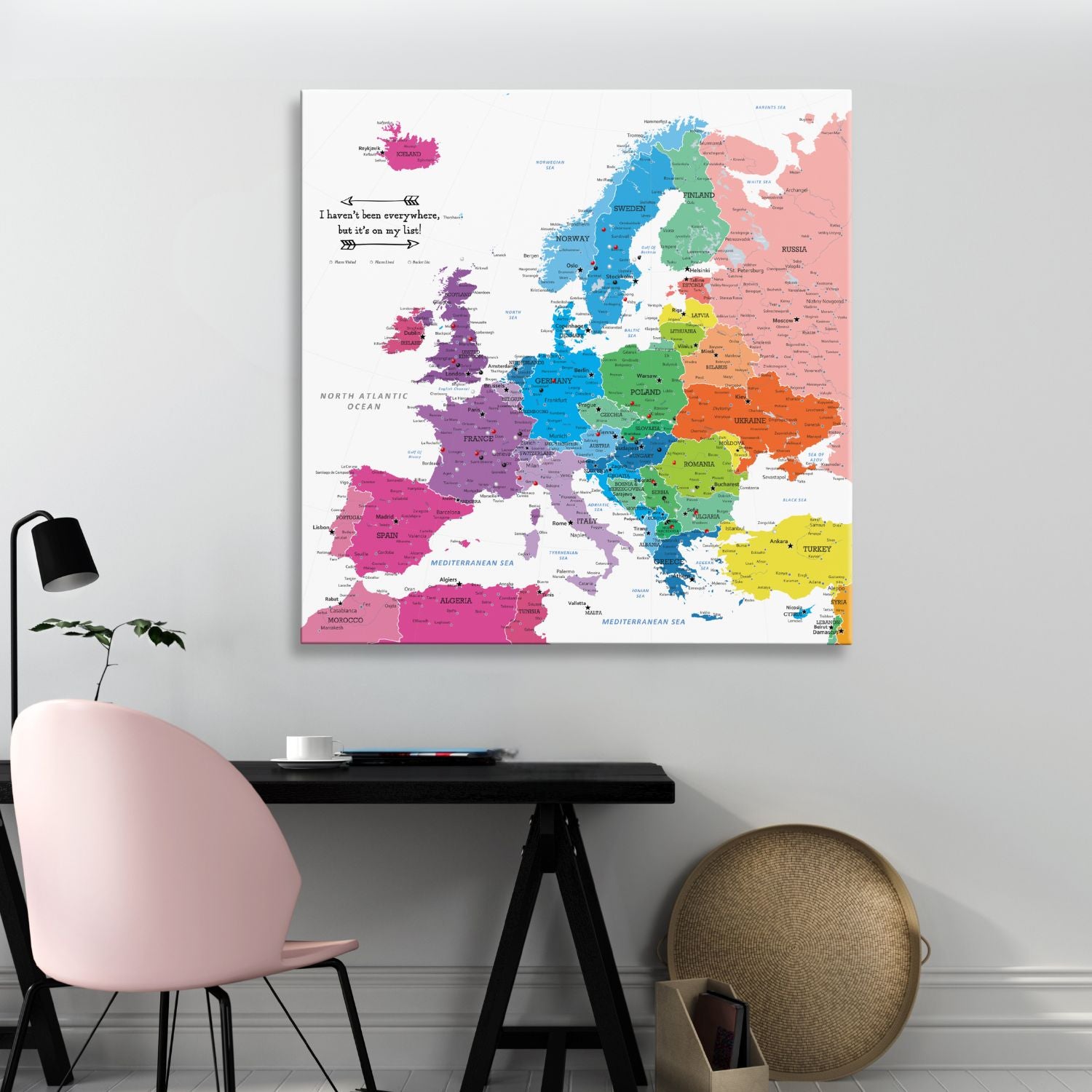Colorful Europe travel push pin map canvas hanging above modern desk workspace