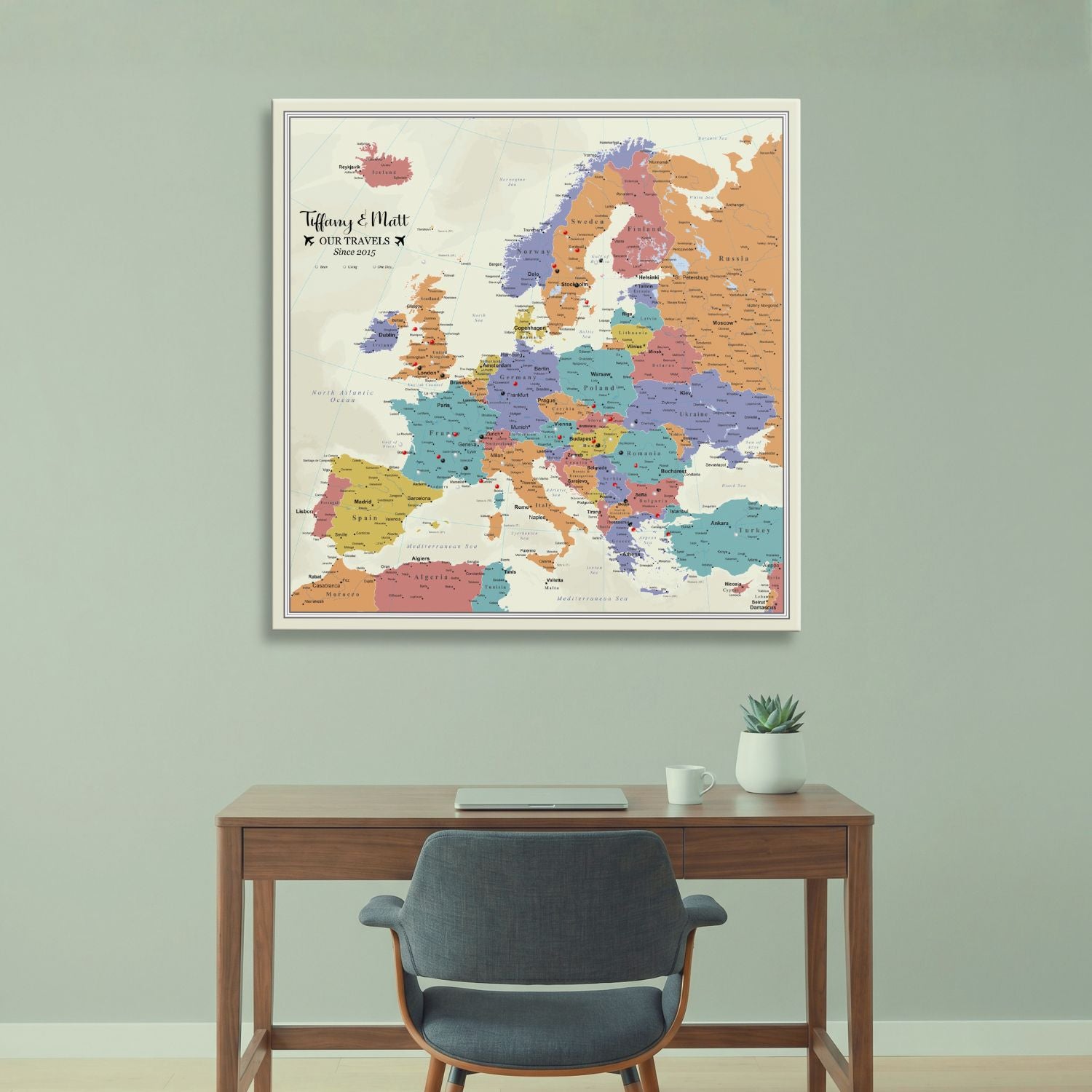 Personalized Europe push pin travel map canvas hanging above wooden desk in home office setting