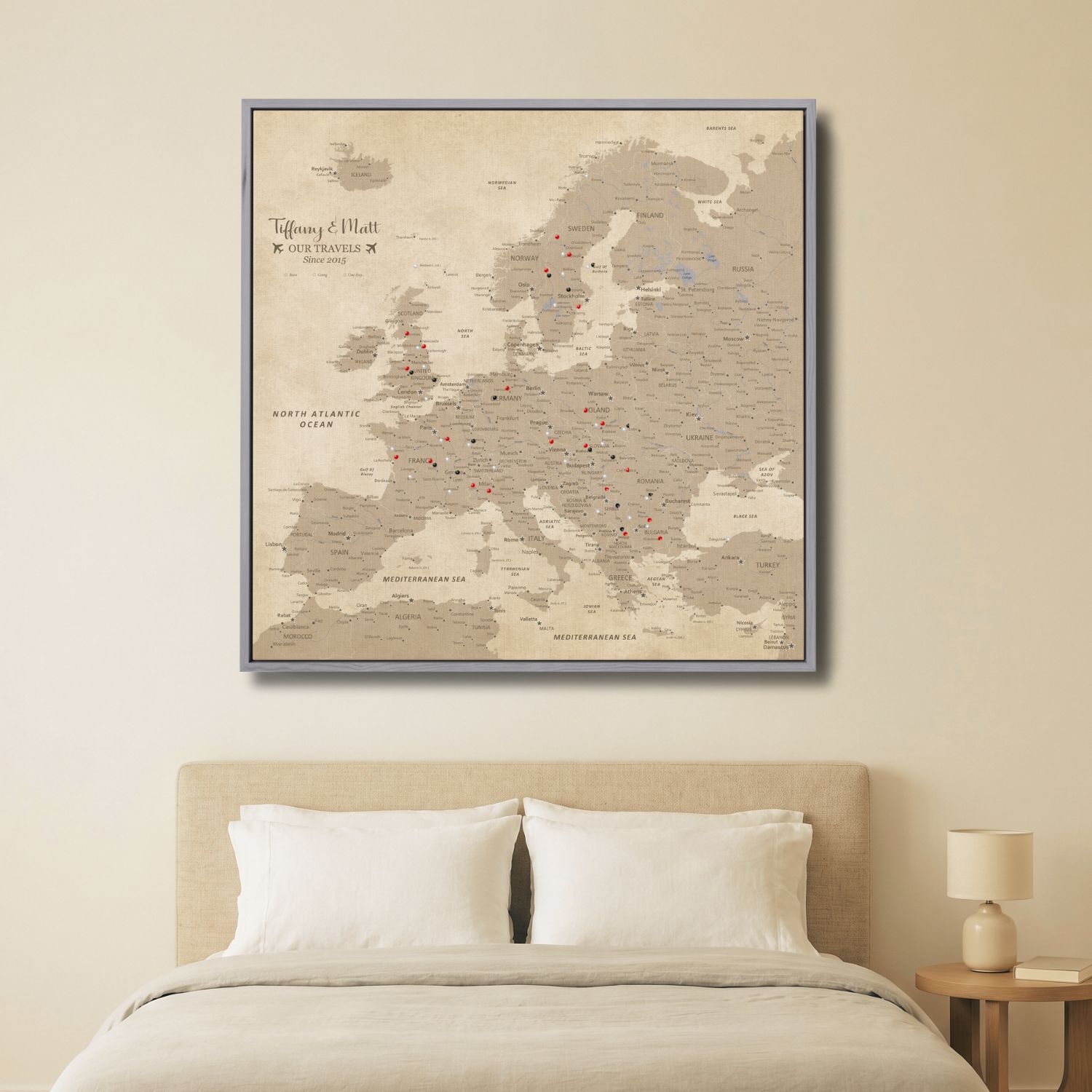 Vintage Europe travel map canvas with red and black pins displayed above bedroom bed in gray frame