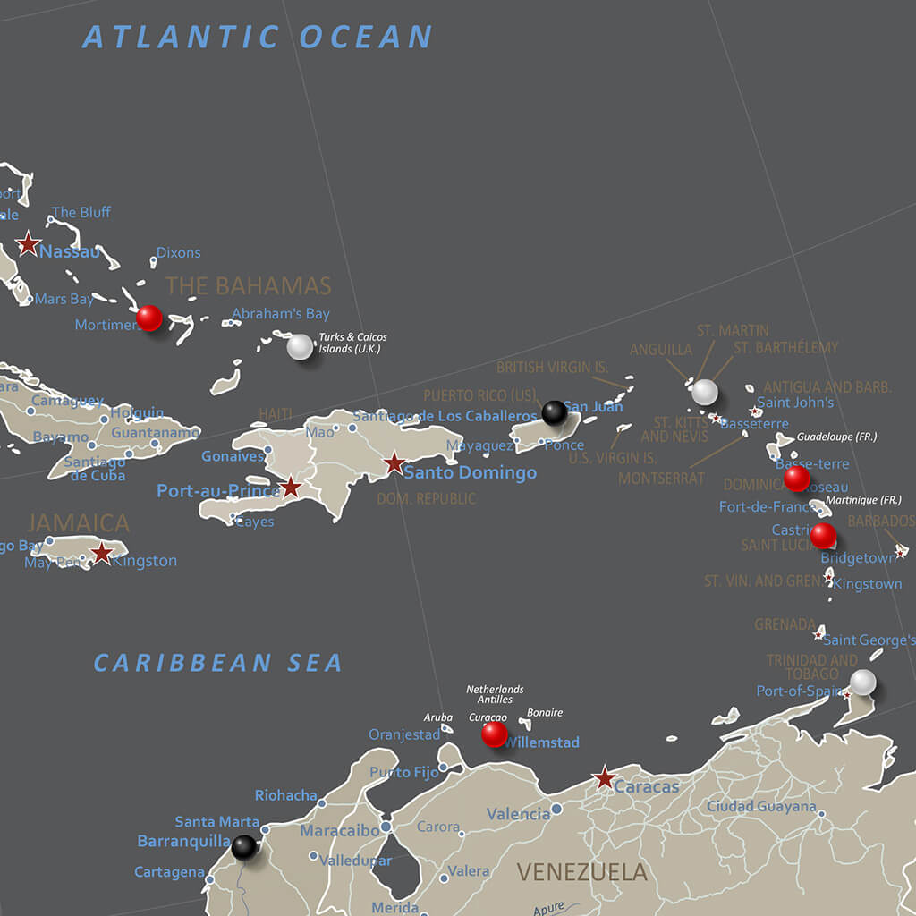 Close-up of earth toned North America travel map showing Caribbean islands with colorful push pins marking destinations