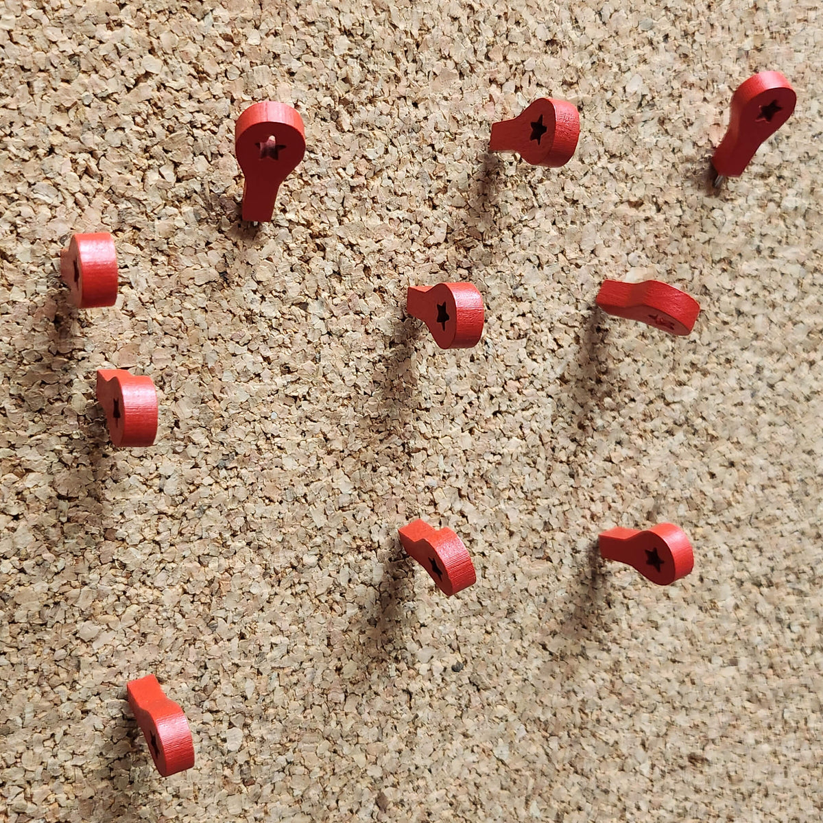 Red Wooden Map Marker Pins on Cork Memo Board Closeup