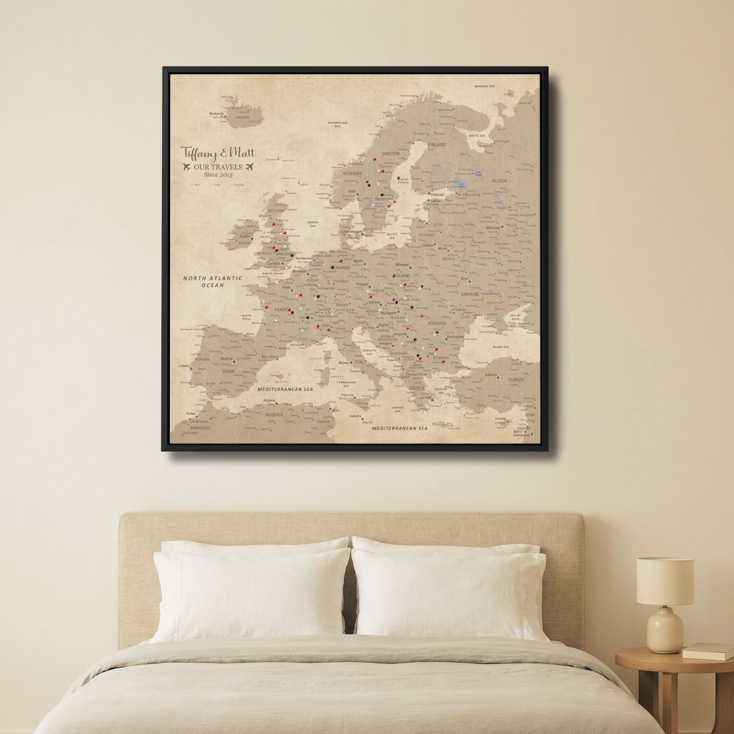 Vintage Europe travel map canvas with pins displayed above bed in neutral beige bedroom décor