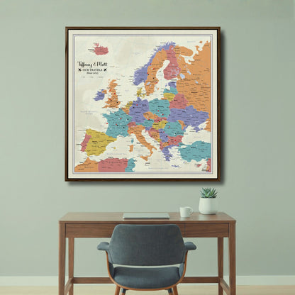 Personalized Europe travel map canvas with pins in dark wood frame above modern desk
