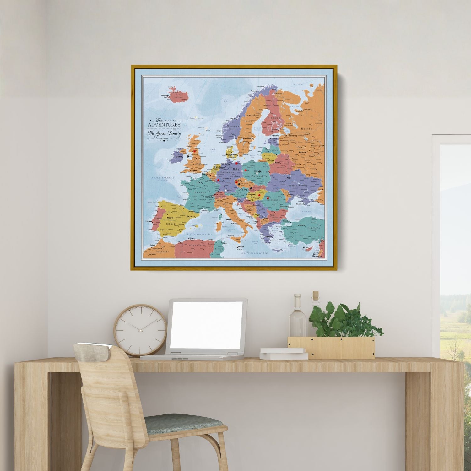 Personalized Blue Oceans Europe travel map with push pins in gold frame displayed above modern wooden desk