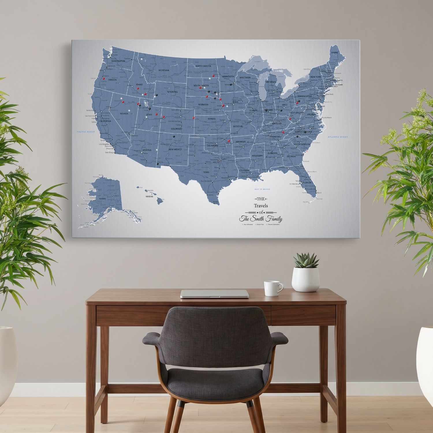 Blue Ice USA travel map with red and black pins hanging above wooden desk in home office