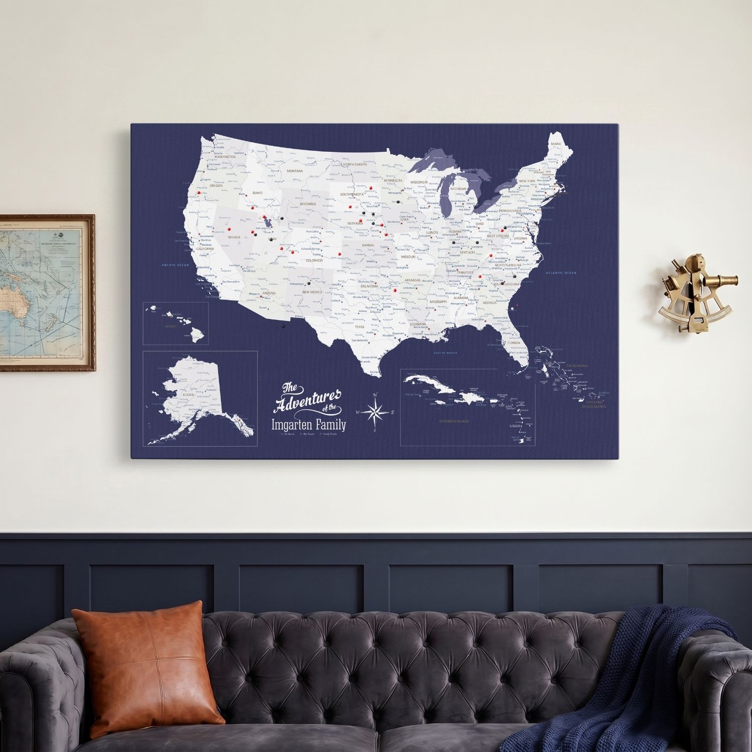 Navy USA Caribbean travel map canvas with red and black push pins hung above tufted sofa in living room