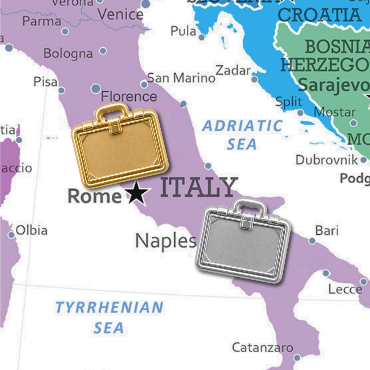 Gold and silver briefcase push pins displayed on colorful Italy map near Rome