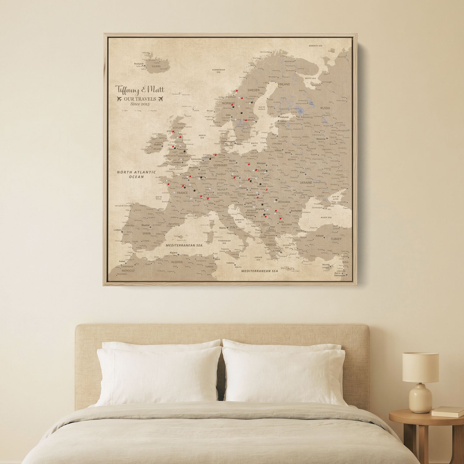Personalized vintage Europe travel map canvas with pins displayed above bed in neutral bedroom décor