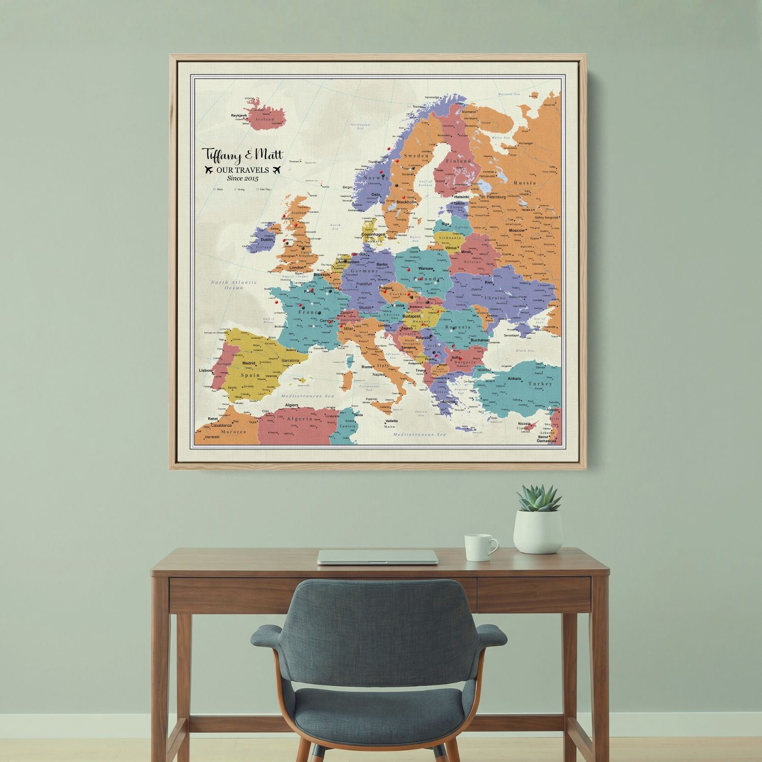 Personalized Europe push pin travel map canvas in wood frame hanging above modern desk
