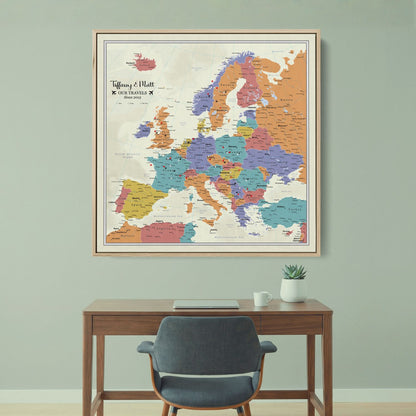 Personalized Europe push pin travel map canvas in wood frame hanging above modern desk