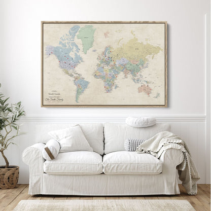 Personalized Sandy Dreams world travel map canvas in natural float frame with red and black push pins hung above white sofa