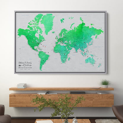 Enchanting Emerald watercolor world travel map canvas with push pins displayed above wooden shelf in modern living room