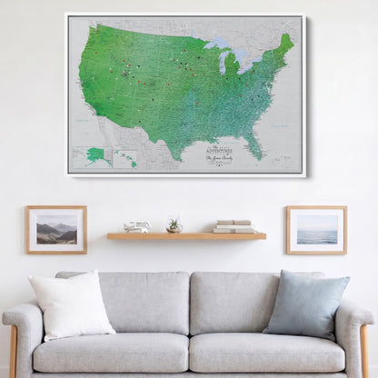 Enchanting Emerald watercolor USA travel map canvas with red and black pins hung above gray sofa in living room